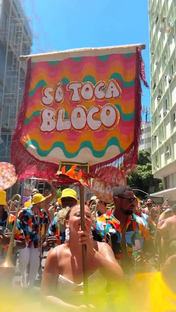 Estandarte do Só Toca Bloco erguido no meio da multidão durante desfile de Carnaval