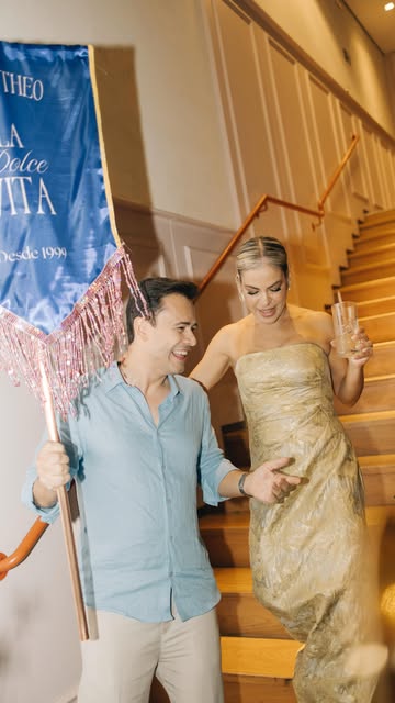 Noivos descendo escadaria com estandarte personalizado do casamento